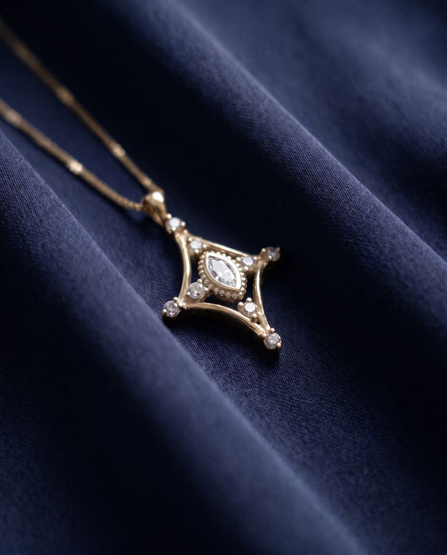 Fine gold chain with a slender pendant set with a marquise lab-grown diamond and small round stones