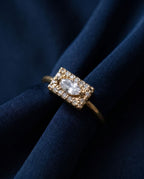 Gold ring with a flat rectangular panel set with a marquise lab-grown diamond and pavé stones