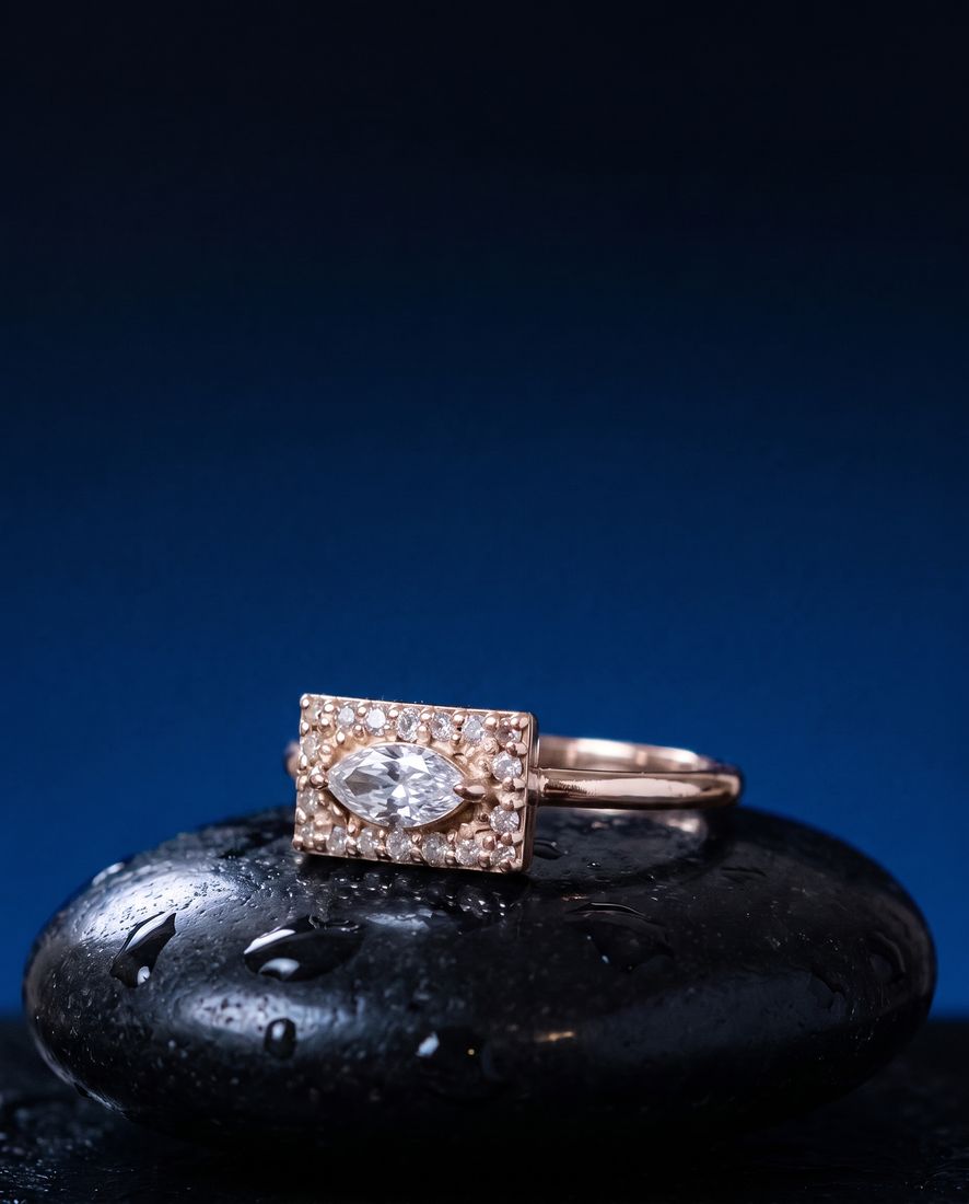 Gold ring with a flat rectangular panel set with a marquise lab-grown diamond and pavé stones