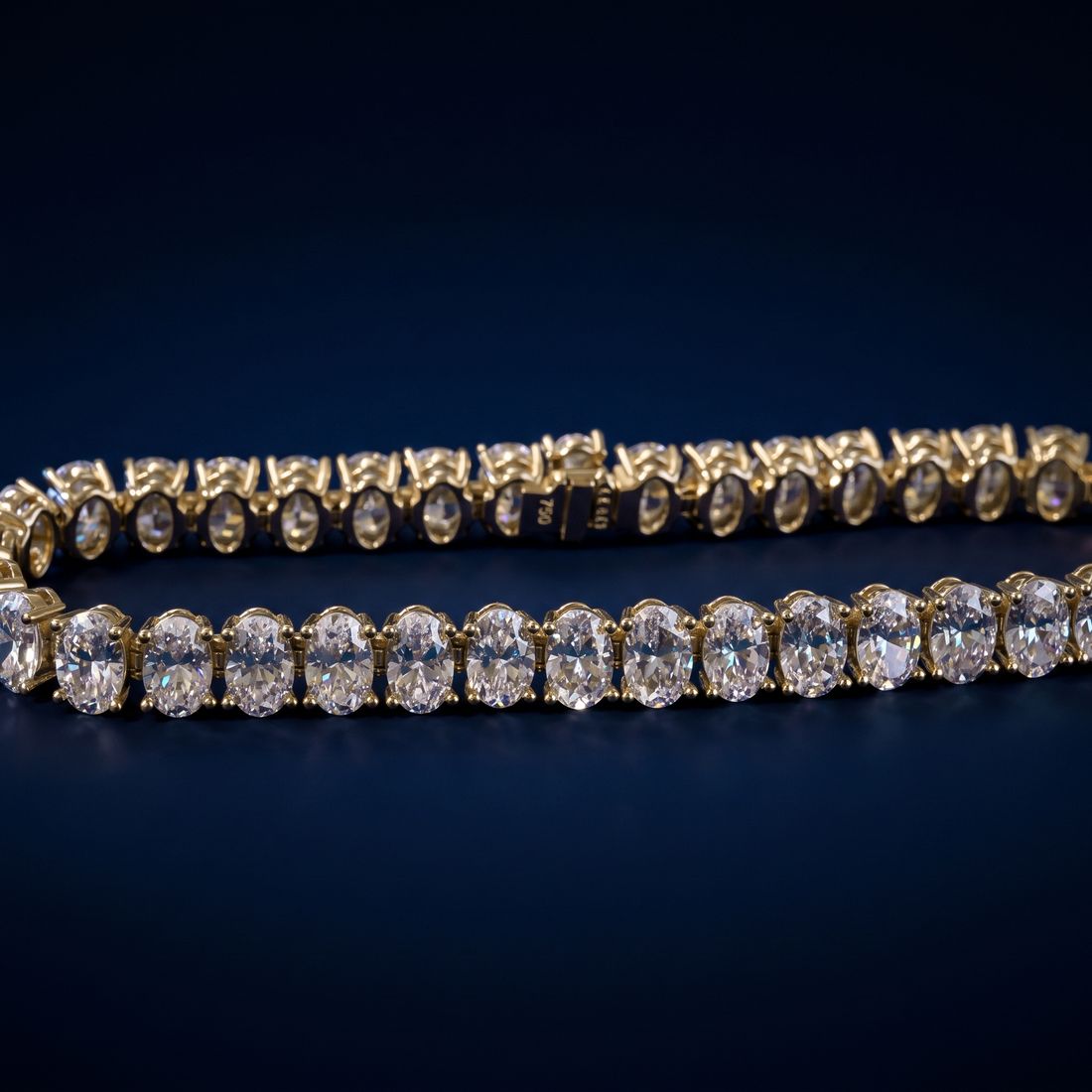 Tennis bracelet of oval-cut lab-grown diamonds set side by side in gold