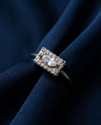 Gold ring with a flat rectangular panel set with a marquise lab-grown diamond and pavé stones