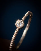 Thin twisted gold band set with a single cognac lab-grown diamond