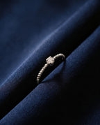 Thin twisted gold band set with a single cognac lab-grown diamond