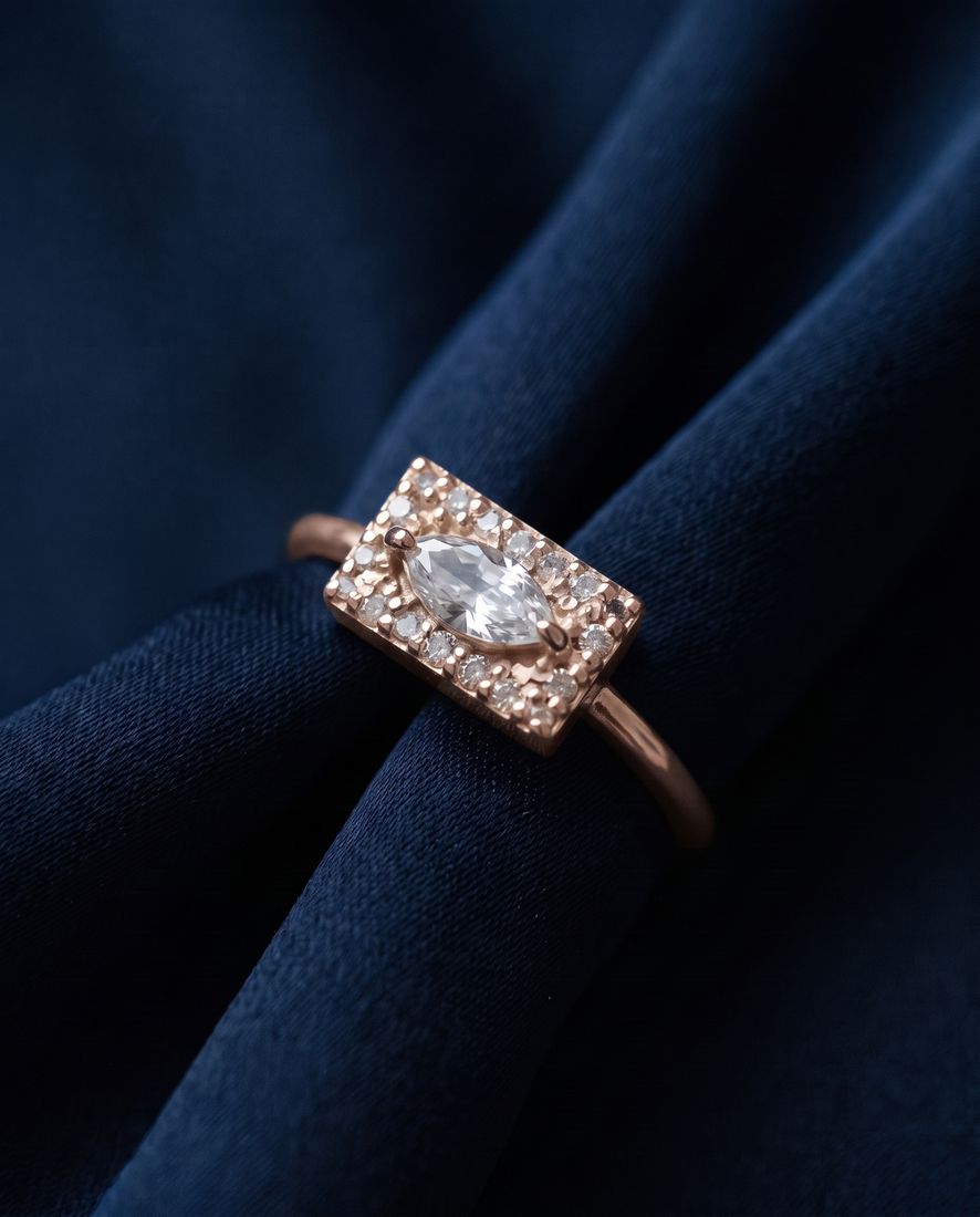 Gold ring with a flat rectangular panel set with a marquise lab-grown diamond and pavé stones
