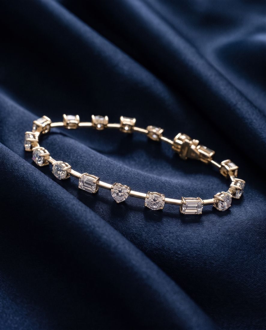 Gold bracelet with sixteen individually set lab-grown diamonds in mixed cuts joined by short polished bars