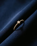 Thin twisted gold band set with a single cognac lab-grown diamond