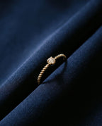 Thin twisted gold band set with a single cognac lab-grown diamond