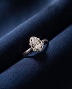 Gold ring with a pear-shaped lab-grown diamond surrounded by a halo of round stones