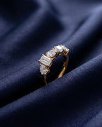 Gold ring set with five lab-grown diamonds in five different cuts along the band