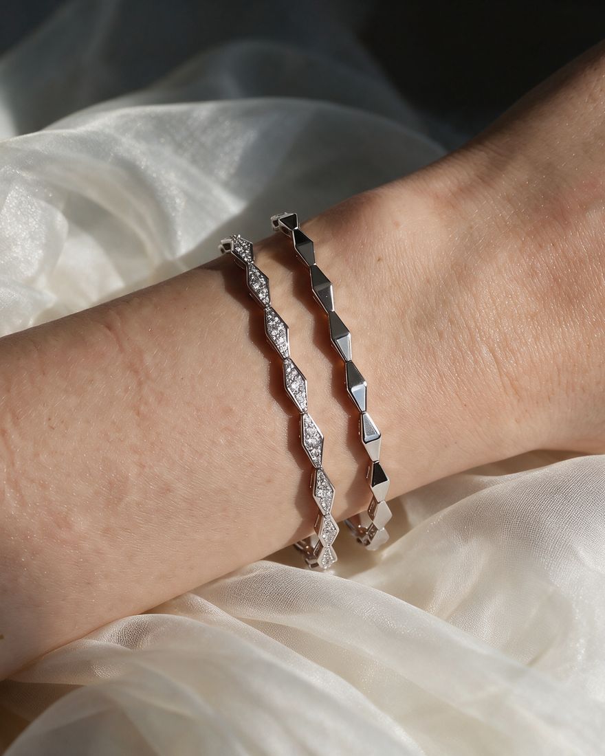 Solid gold bracelet of faceted rhombus links pavé-set with small round lab-grown diamonds, shown on a plain ground