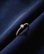 Thin twisted gold band set with a single cognac lab-grown diamond
