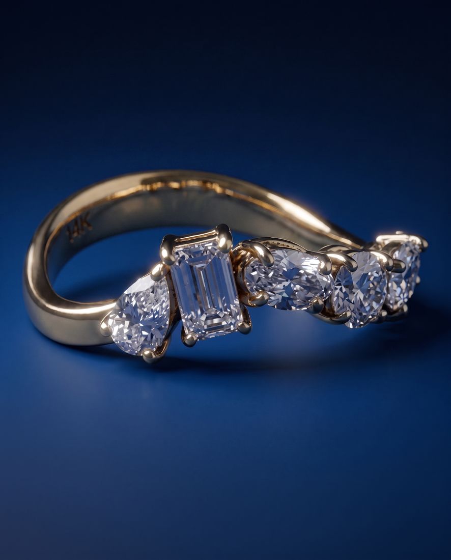 Gold ring set with five lab-grown diamonds in five different cuts along the band