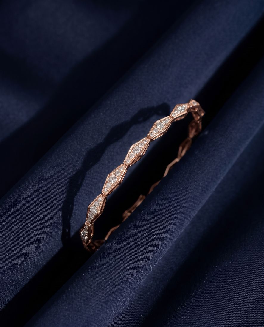 Solid gold bracelet of faceted rhombus links pavé-set with small round lab-grown diamonds, shown on a plain ground