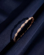 Solid gold bracelet of faceted rhombus links pavé-set with small round lab-grown diamonds, shown on a plain ground