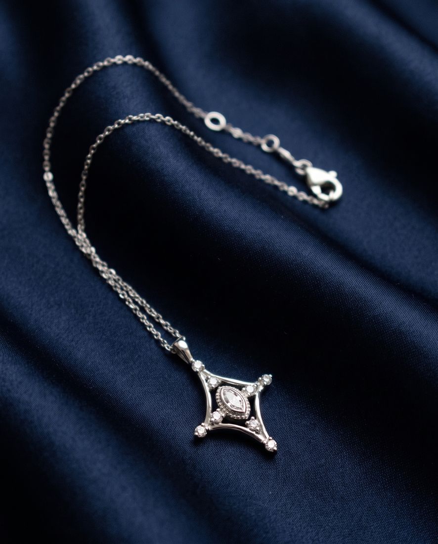Fine gold chain with a slender pendant set with a marquise lab-grown diamond and small round stones