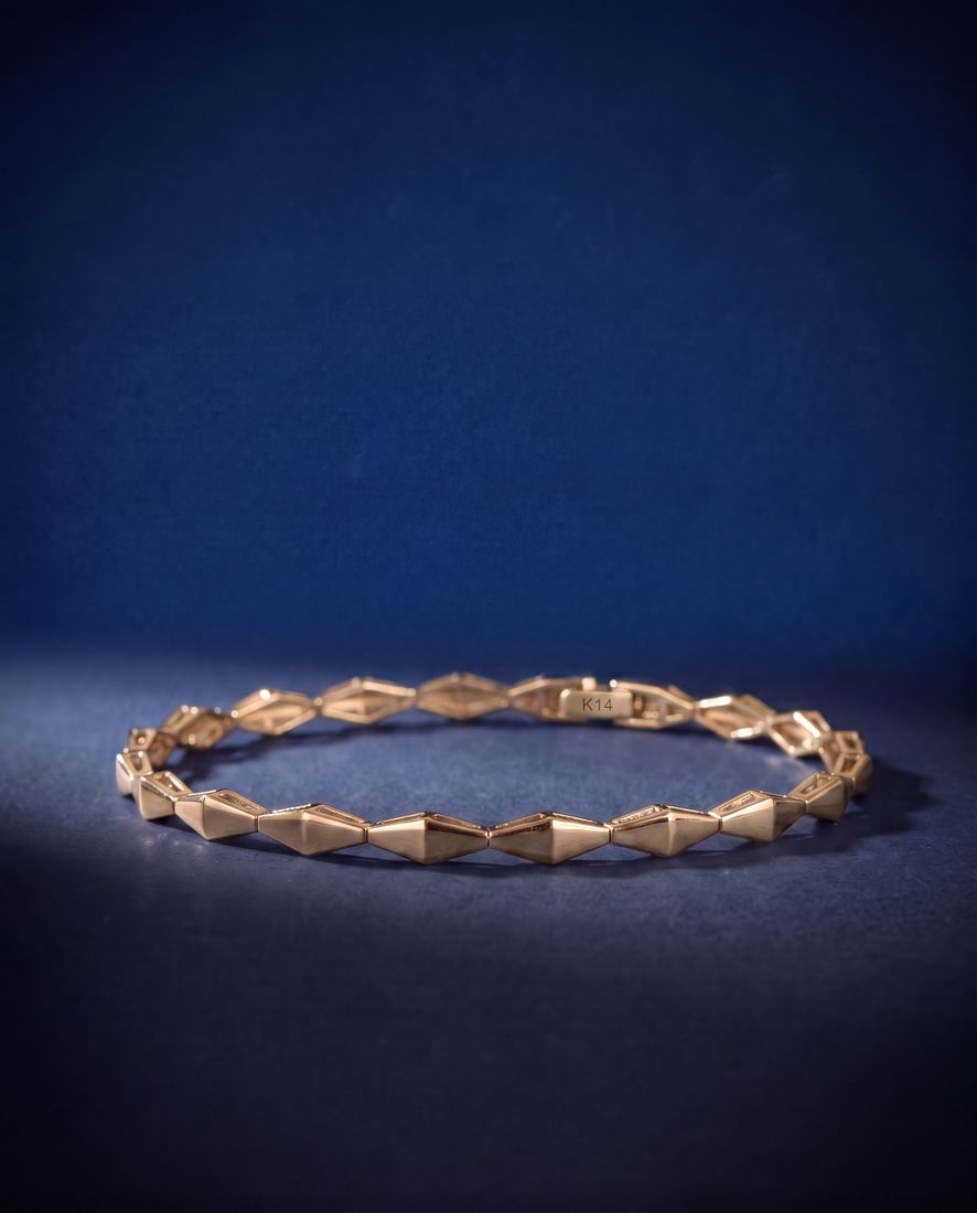 Plain solid gold bracelet of faceted rhombus links joined tip to tip