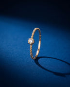 Thin twisted gold band set with a single cognac lab-grown diamond