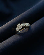Gold ring set with five lab-grown diamonds in five different cuts along the band