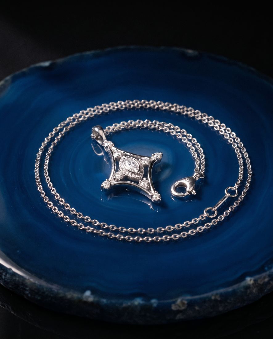 Fine gold chain with a slender pendant set with a marquise lab-grown diamond and small round stones